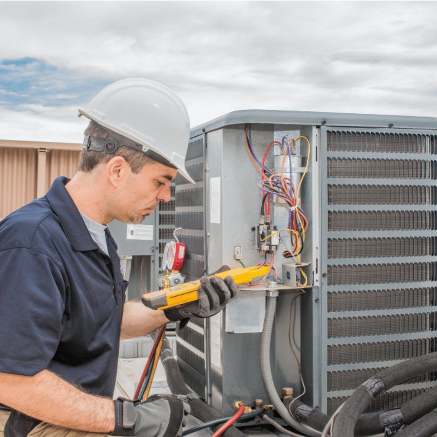 Caledonia Heating & Cooling HVAC technician servicing a system